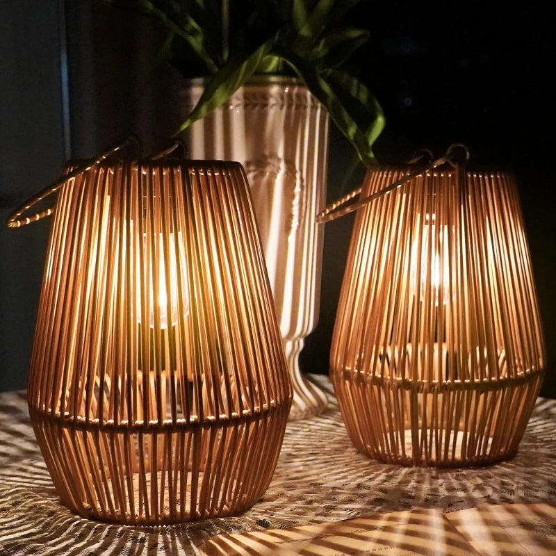Two solar rattan lanterns glowing on a lace-covered table at night